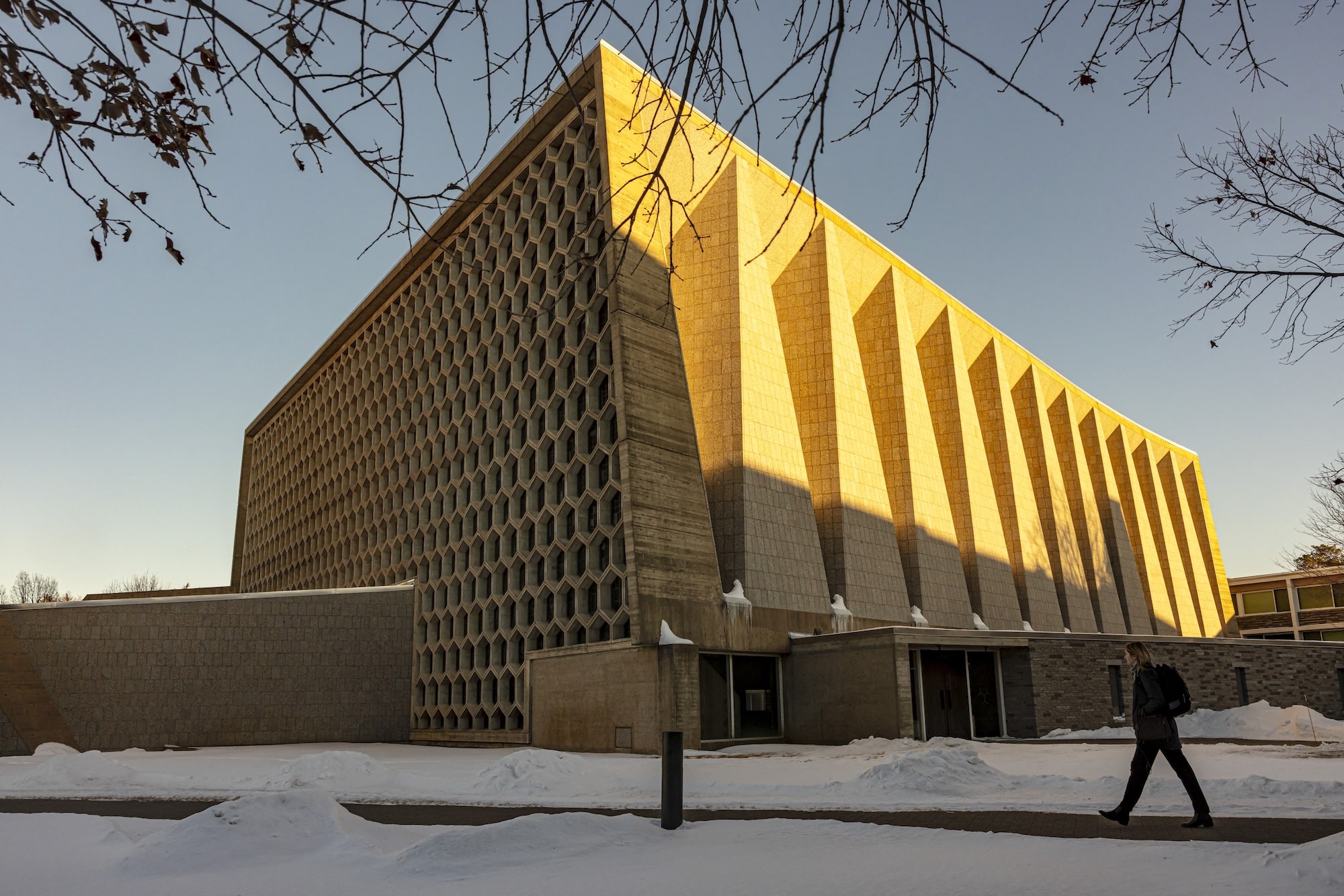 A person walks past Saint John's Abbey in Collegeville, Minnesota, at sunset on February 18, 2025. On a snowy prairie in Minnesota stands a monastery like no other. For half a century, the existence of this masterpiece designed by modernist architect Marcel Breuer, has been mainly known to the Benedictine monks who worship there, and the hordes of architects who make pilgrimages to Saint John's Abbey Church each summer.But these days, it is finding new fame as the basis for "The Brutalist," the epic drama about an immigrant architect, haunted by the Holocaust, that is a favorite to win best picture at the Oscars. (Photo by Kerem YUCEL / AFP)