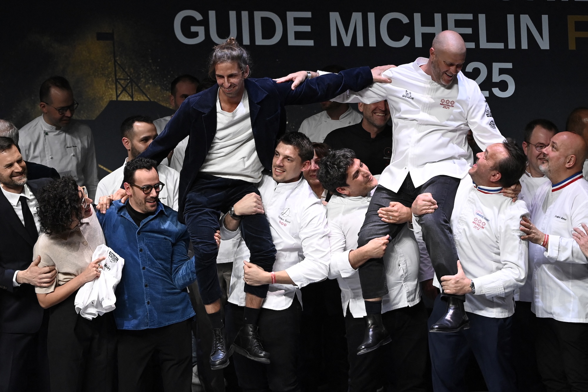 French chefs Hugo Roellinger (C-L) and Christopher Coutanceau (C-R) are congratulated after they were awarded with three Michelin stars during the Michelin Guide for France 2025 awards ceremony in Metz, eastern France on March 31, 2025. (Photo by Jean-Christophe VERHAEGEN / AFP)