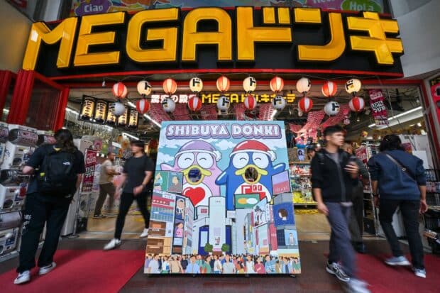 This photo taken on April 21, 2025 shows the entrance to a branch of Japanese discount retailer Don Quijote, also known overseas as Don Don Donki, in the Shibuya district of central Tokyo. In the narrow, crowded aisles of a department store in Tokyo's Shibuya district, hundreds of tourists rush to fill their baskets with snacks, gadgets, and souvenirs of all kinds, fuelling sales at Don Quijote, the king of Japanese discount stores. (Photo by Richard A. Brooks / AFP) / TO GO WITH AFP STORY JAPAN-TOURISM-ECONOMY-RETAIL,FOCUS BY CAROLINE GARDIN AND ATISH PATEL